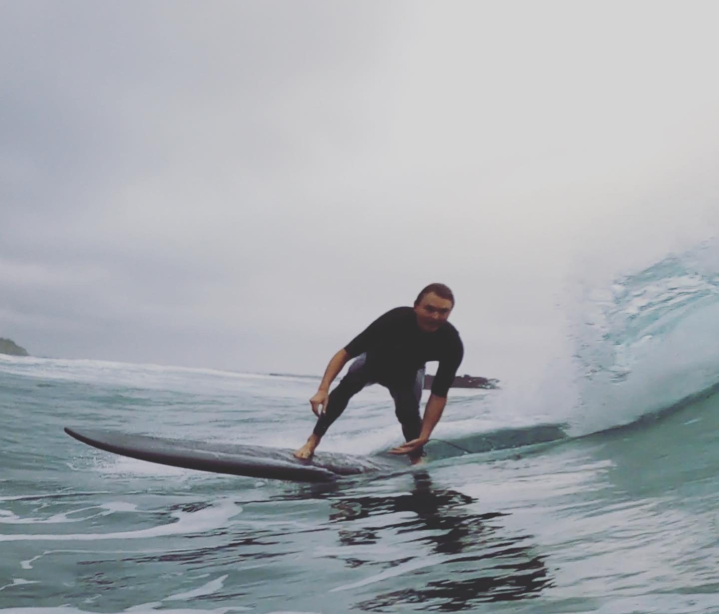 VESL soft top longboard carving on a small right-hand wave