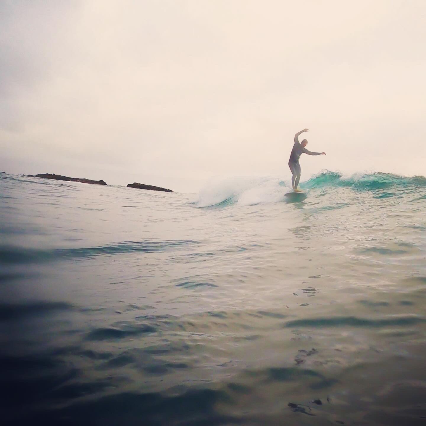 VESL Soft Top Longboard resting on the sand near the water